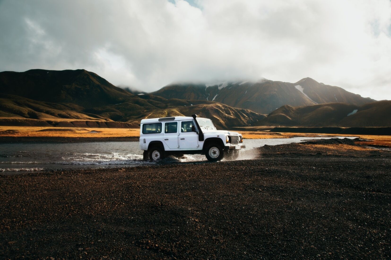 A 4WD emerging from a river on one of New Zealand's best road trips